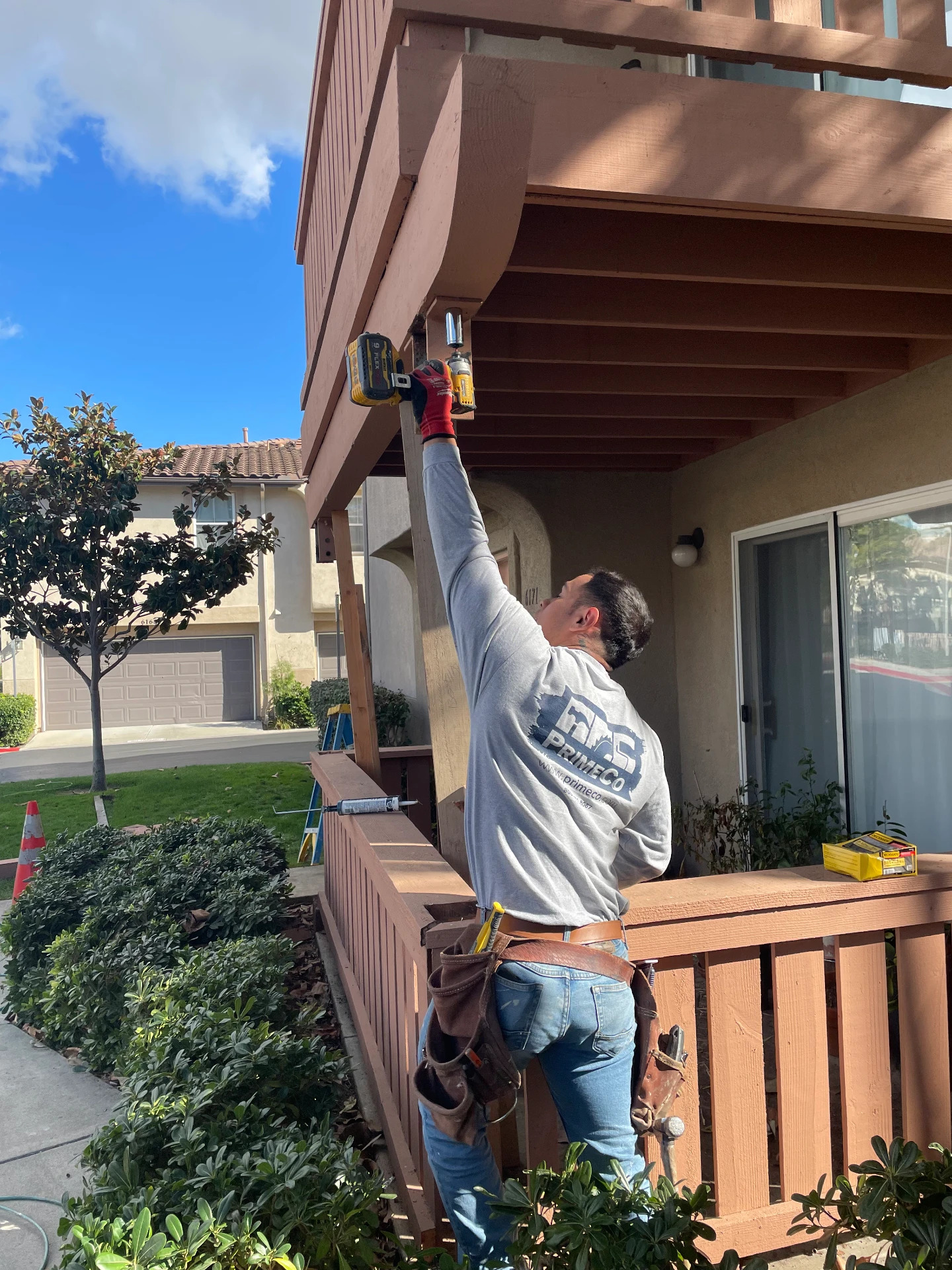 PrimeCo crew member installing deck hardware with a power drill