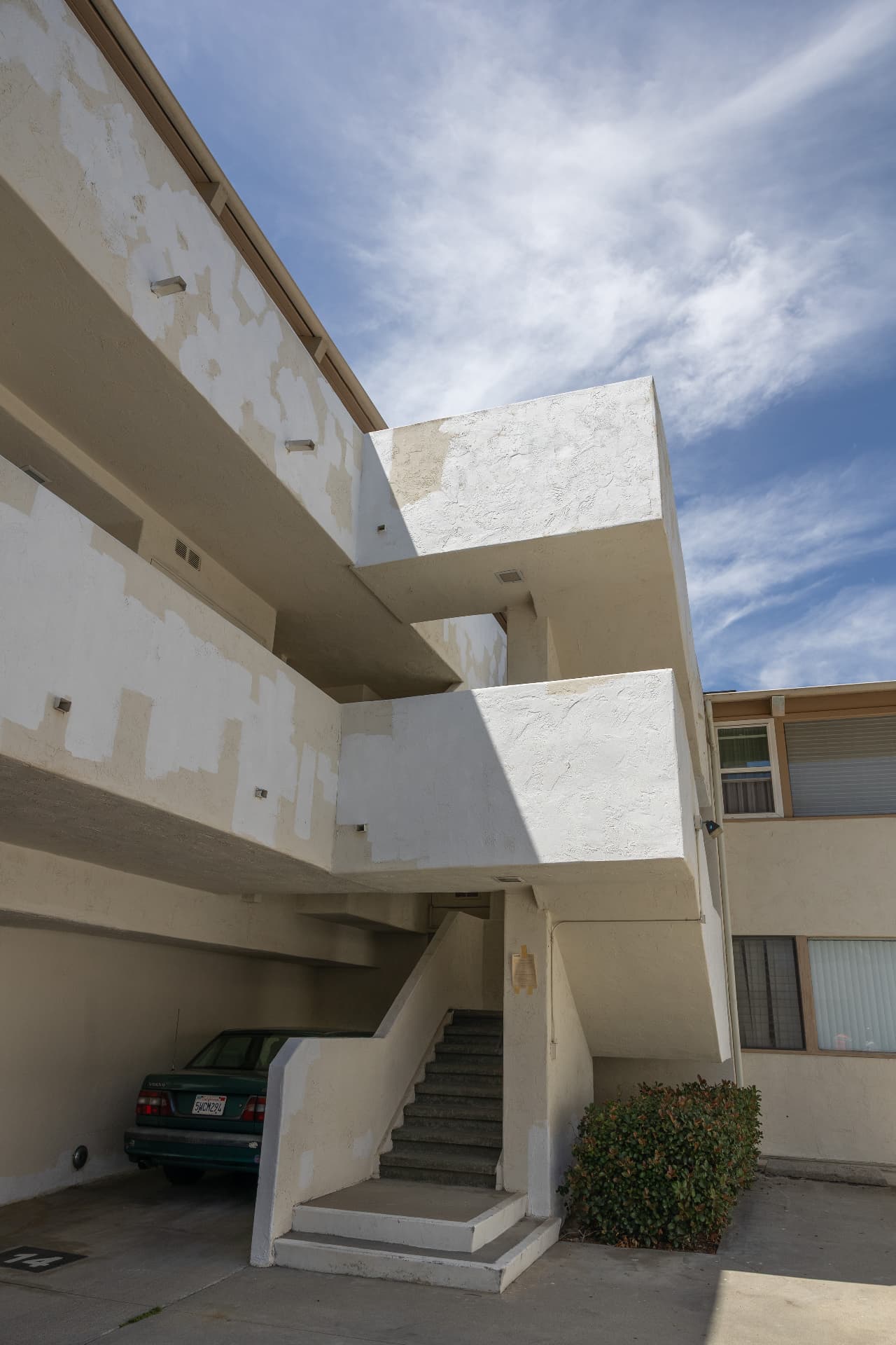 Stairwell before restoration — patched and weathered stucco